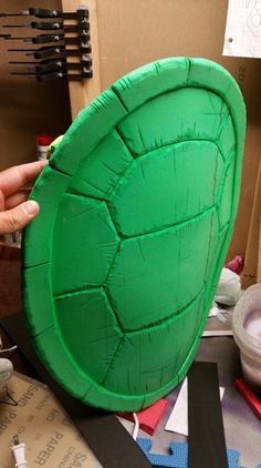 a person holding up a paper plate shaped like a turtle