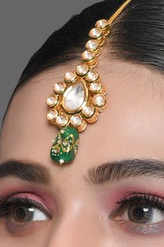 Add this Kundan mang tika to your jewellery collection and shine at the next ethnic event. Embellished with beads, it is truly a stunning piece to flaunt this season. Product Features: Color: Kundan Gold toned green beaded Mang tika Material: Metal copper alloy,semiprecious tanjore beads work : kundan with meenkari on back side Dimension: Length 5.9 in, width -1.5 in Pack Of: Mang tika Occasion: festive and wedding Disclaimer: There will be slight difference in digital to actual image