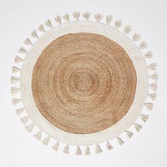 a round woven rug with tassels on top