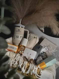 an assortment of items sitting on top of a table next to a plant and mirror