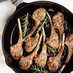 steaks with black beans and rosemary in a cast iron skillet on a marble countertop