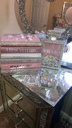 a mirrored table topped with lots of pink and silver boxes filled with jewelry next to a mirror