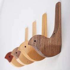 three wooden birds are hanging on the wall