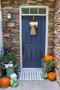 a blue front door with pumpkins and gourds