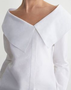 Defined by a feminine off-shoulder portrait neckline, this addition to L148's lineup of signature white shirts is sharply tailored from crisp, organic cotton poplin with an oversized foldover collar—a nod to vintage sailor uniforms and the House's Brooklyn Navy Yard design atelier. The fitted silhouette is sculpted by waist-defining darts and clean-finished with a concealed, off-center button placket.Shop all Blouses White Vintage Blouse, White Poplin Shirt, Portrait Neckline, Brooklyn Navy Yard, Design Atelier, Sailor Shirt, Vintage Sailor, 2024 Design, Yard Design