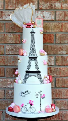 a three tiered cake with the eiffel tower on it's side