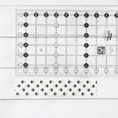 the ruler is next to an empty piece of paper with black and white flowers on it