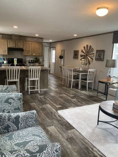 a living room filled with furniture next to a kitchen and dining room table in a home