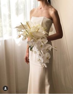 a woman in a white dress holding a bouquet of flowers