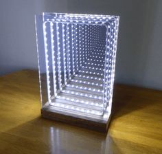 an illuminated cube sitting on top of a wooden table