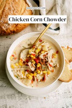 a white bowl filled with chicken corn chowder next to some bread on the side