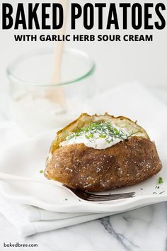 a baked potato on a plate with a fork and glass of water in the background