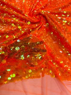 an orange fabric with lots of shiny beads on it