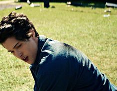 a young man crouching down in the grass