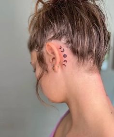 a woman with tattoos on her neck and behind the ear