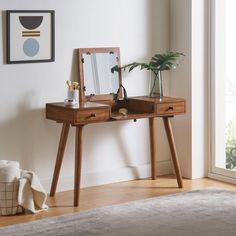 a wooden desk with a mirror and plant on it