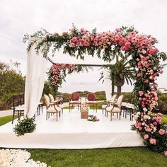 an outdoor wedding setup with flowers and greenery on the ground, surrounded by chairs