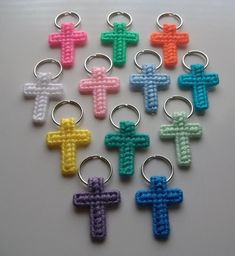 small crocheted cross keychains in different colors on a white table top