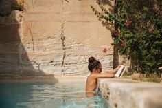 a woman sitting in a pool reading a book