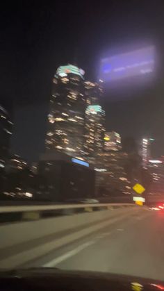 the city skyline is lit up at night with bright lights on it's side