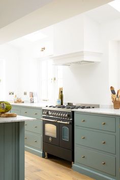 a kitchen with green cabinets and an oven