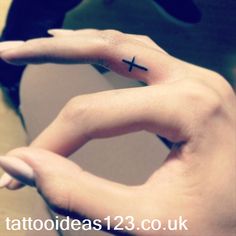 a person with a cross tattoo on their left hand