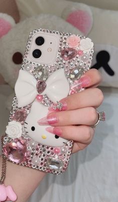 a person holding a hello kitty phone case in their hand