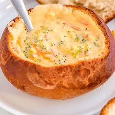 a close up of a bowl of soup on a plate with bread and other food