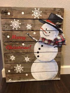 a wooden pallet with a snowman painted on it