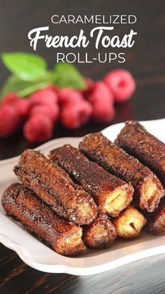 caramelized french toast roll - ups on a plate with raspberries in the background