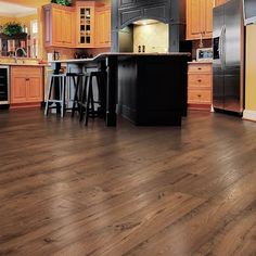 a large kitchen with wooden floors and cabinets