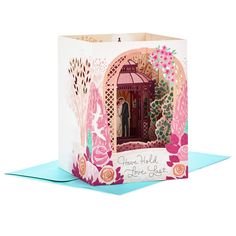 a greeting card with an image of a bride and groom in a pink gazebo