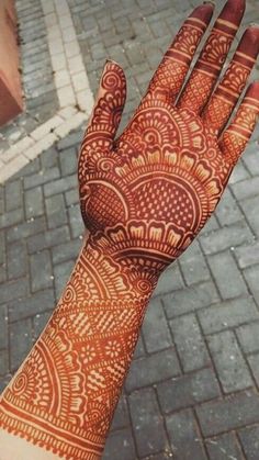 someone's hand with henna tattoos on it