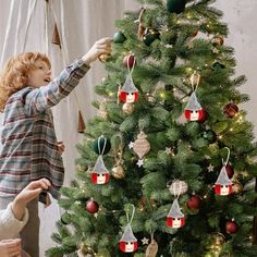 two women decorating a christmas tree with ornaments