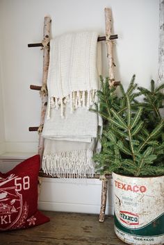 a christmas tree in a bucket next to a towel rack