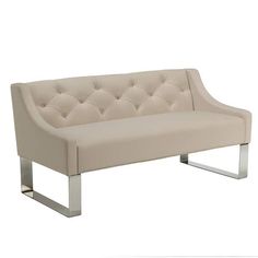 a white couch sitting on top of a metal frame bench with tufted upholstered cushions