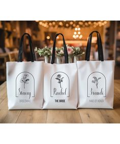 three bags sitting on top of a wooden table next to each other with flowers in them