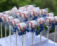 baseball cake pops with blue bows are ready to be served for the guests at a baseball themed birthday party