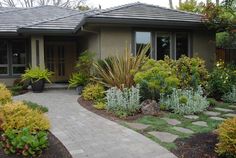 a house with landscaping in the front yard and walkway leading up to it's entrance