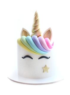 a white cake topped with a rainbow colored unicorn's face