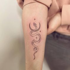 a woman's arm with a tattoo on it that has a crescent and stars