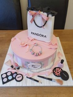 a pink cake with a bag and makeup on it sitting on top of a table