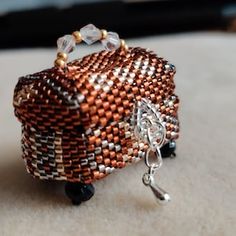 a beaded purse sitting on top of a table next to a keychain