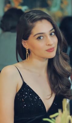 a woman in a black dress sitting at a table