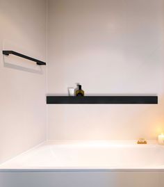 a white bath tub sitting next to a candle