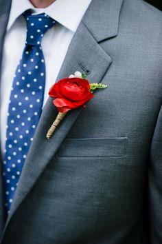 a man wearing a suit and tie with a boutonniere on his lapel