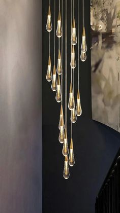 a chandelier hanging from the side of a wall next to a stair case