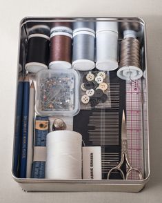 sewing supplies are organized in a metal container