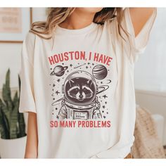 Houston I Have So Many Problems graphic unisex t shirt. *Product Details* -The print method is DTG (Direct to Garment). This is ink, not vinyl. This is a vibrant, permanent print. - Print color varies slightly depending on the shirt color - Solid colors are 100% ring-spun cotton - Heather colors are 65% polyester, 35% ring-spun cotton - Print color varies depending on the shirt color Funny Print Graphic Tee, Pop Culture Sublimation Crew Neck T-shirt With Graphic Print, Pop Culture Sublimation Graphic Crew Neck, Racoon, Printing Methods, Shirt Color, Unisex T Shirt, Houston, Solid Colors