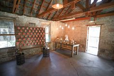 a room with stone walls and wooden ceilinging, two vases are on the table